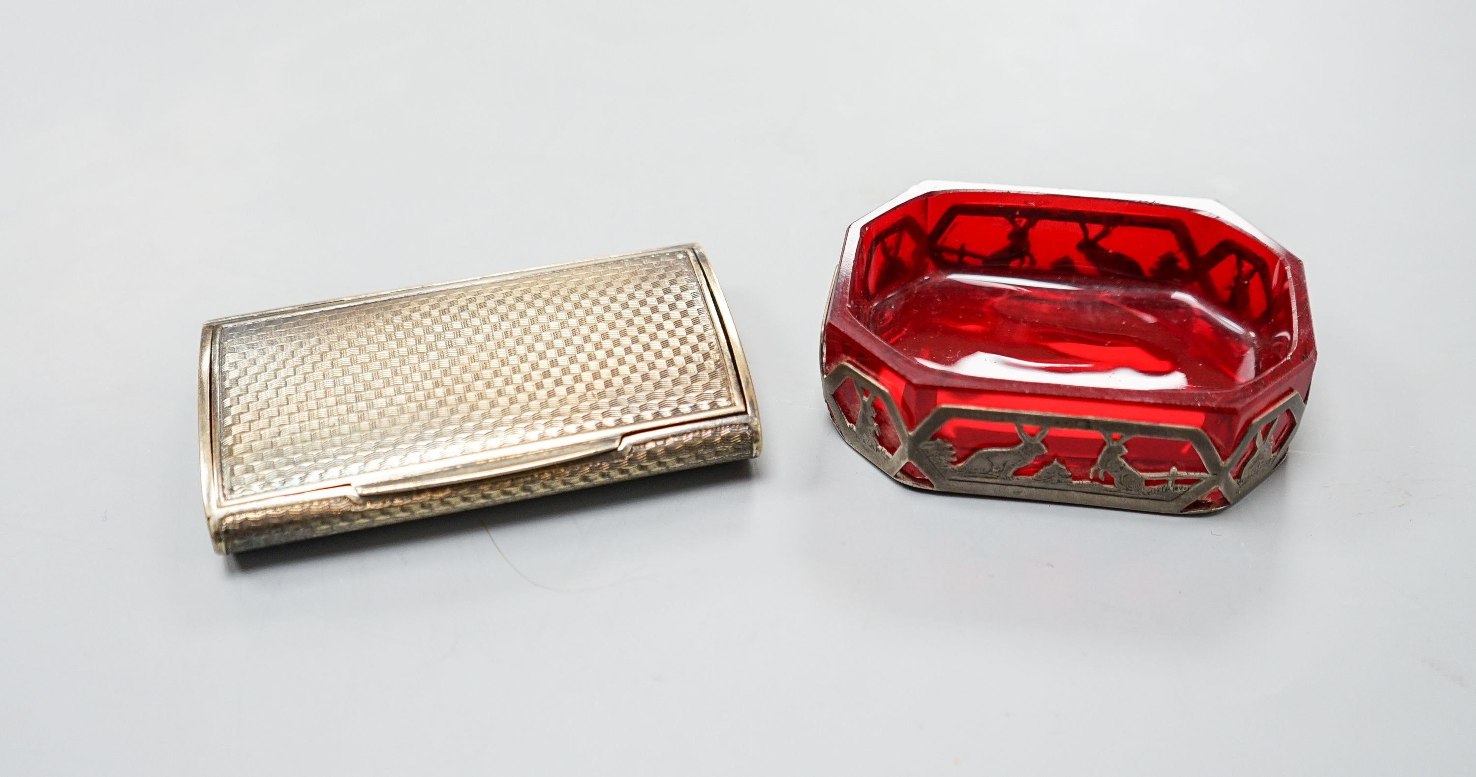 An early 20th century Austro Hungarian gilt white metal snuff box, 82mm and a similar later mounted ruby glass dish, 72mm.
